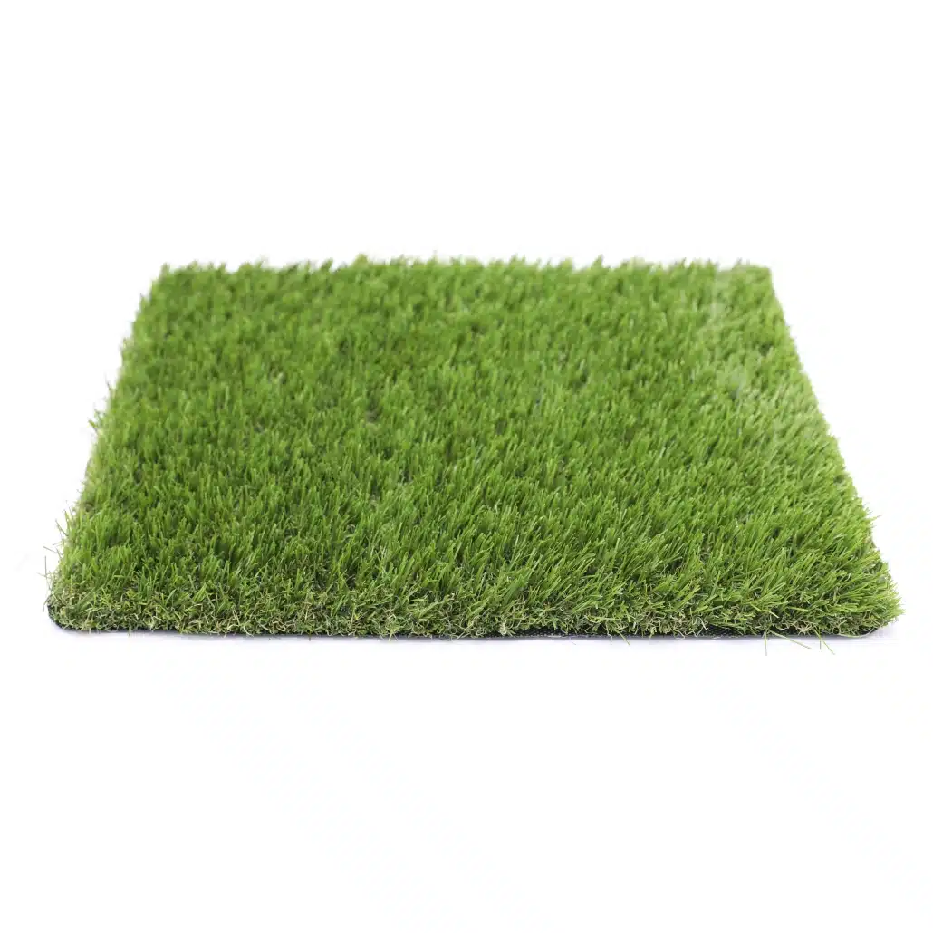 Una pieza rectangular de Césped artificial ADRIÁTICO 30mm, densa y verde, es fotografiada desde un ángulo bajo sobre un fondo blanco.